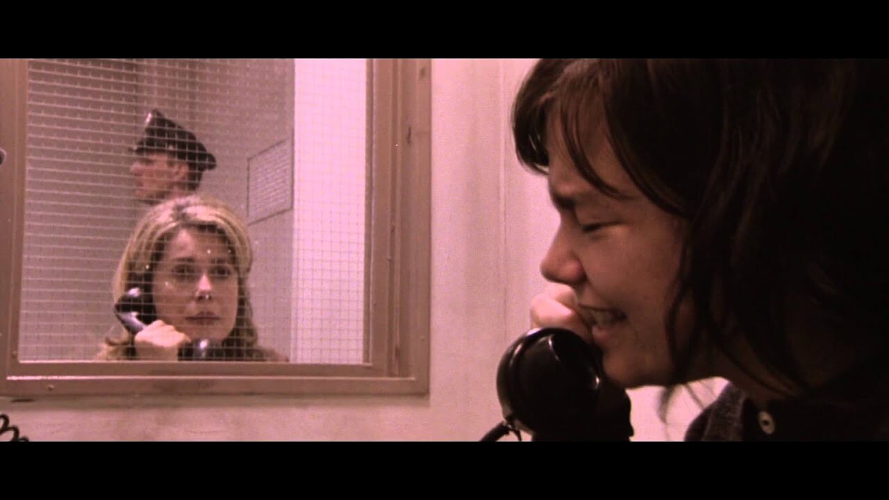 Björk qui communique au parloir avec Catherine Deneuve en pleurant et tenant le combiné de téléphone noir. On y voit un flic en arrière plan