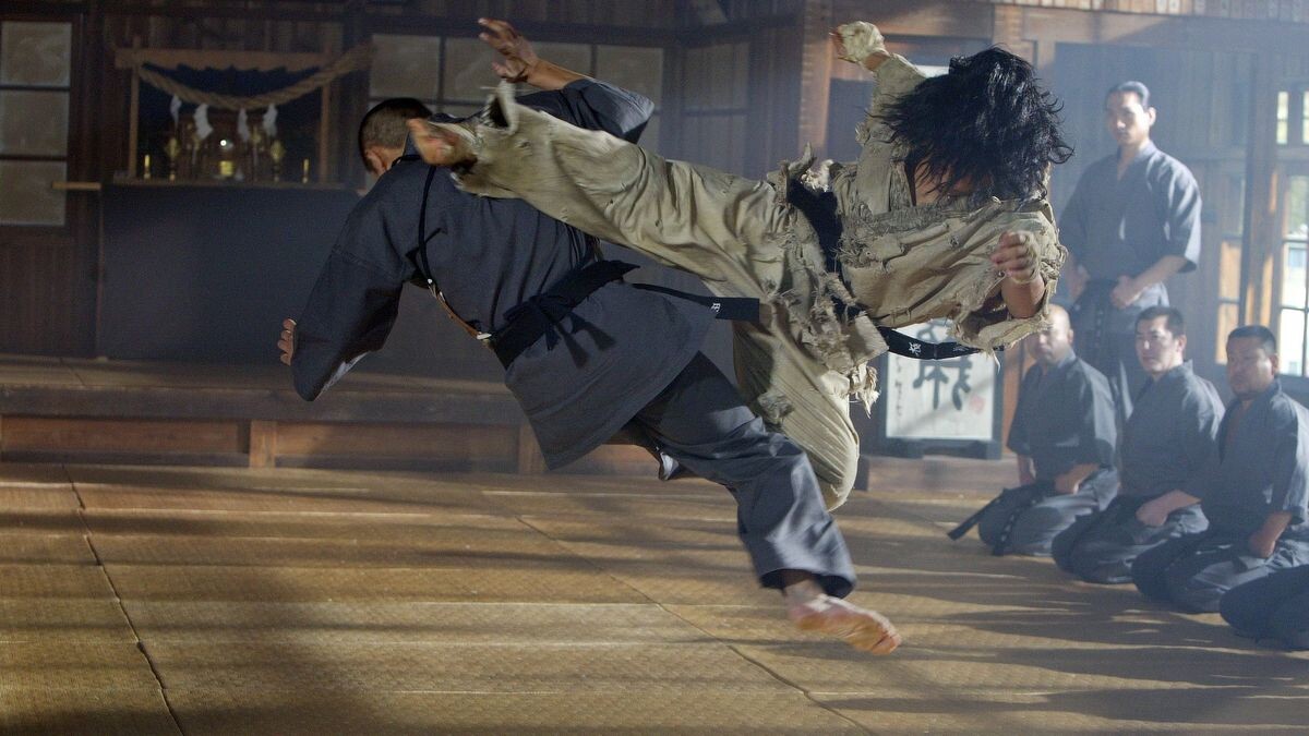 Choi bae dal en plein combat dans un dojo rempli de karatéka