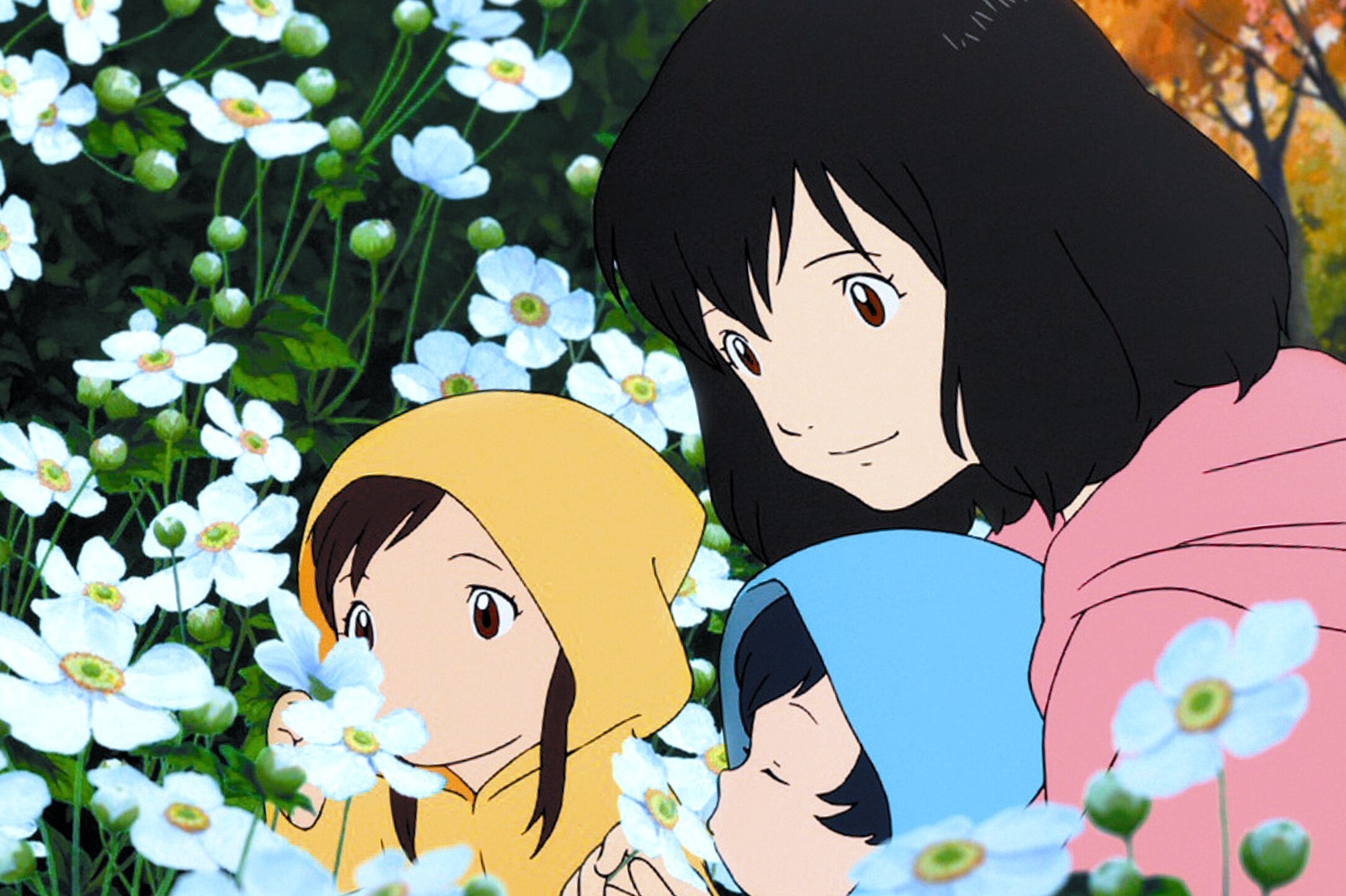 Les enfants qui se promènent dans un parc avec leur maman et qui respirent le parfum des fleurs. Les enfants portent des capuches.