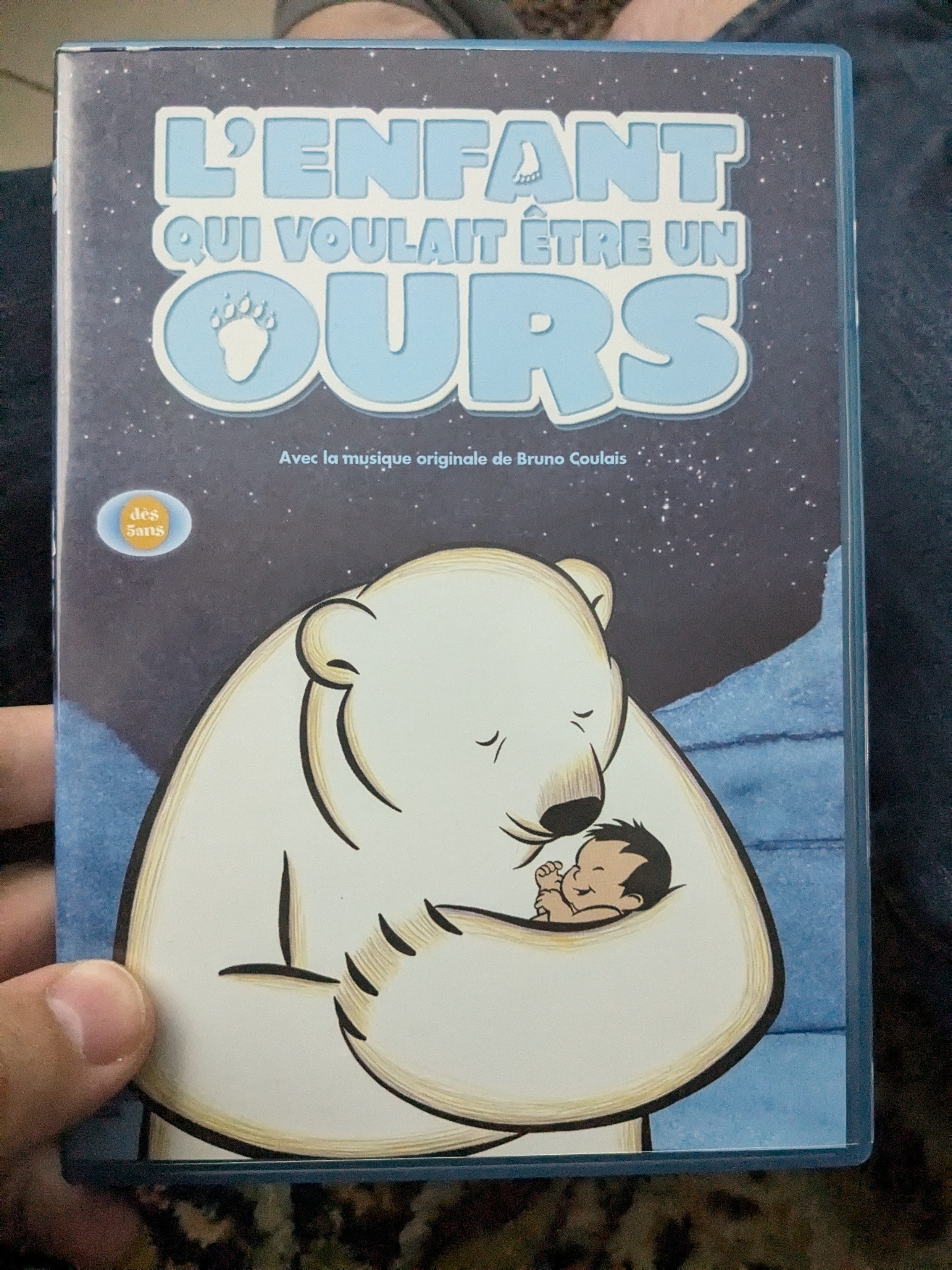 La jaquette du film où l'on voit une ours porter à ses bras un enfant inuit sous fond de ciel nocturne etoilé