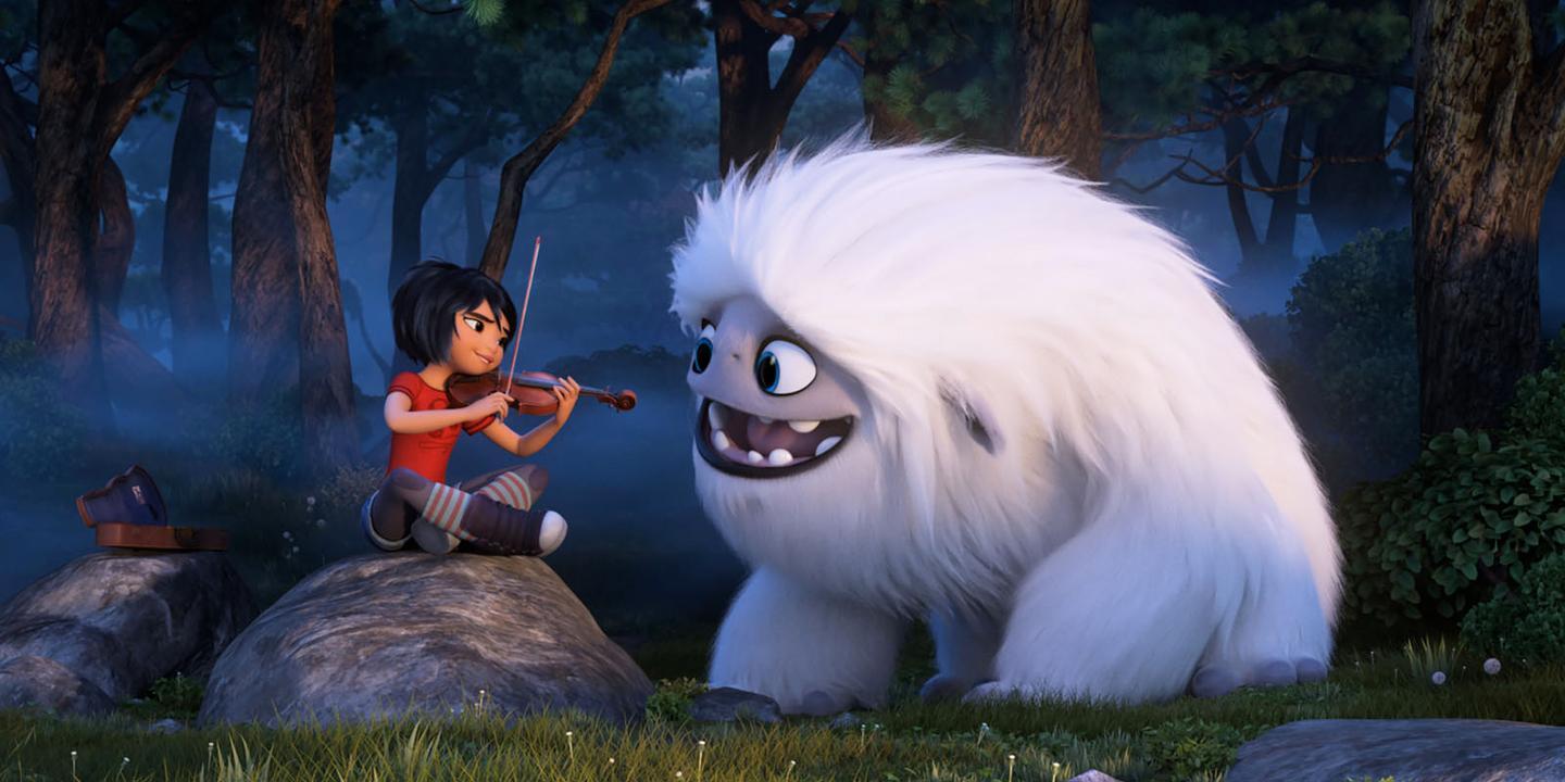 Yo qui joue du violon dans la forêt sur un rocher avec à sa droite le Yeti grosse boule de poils blanc qui l'écoute attentivement.