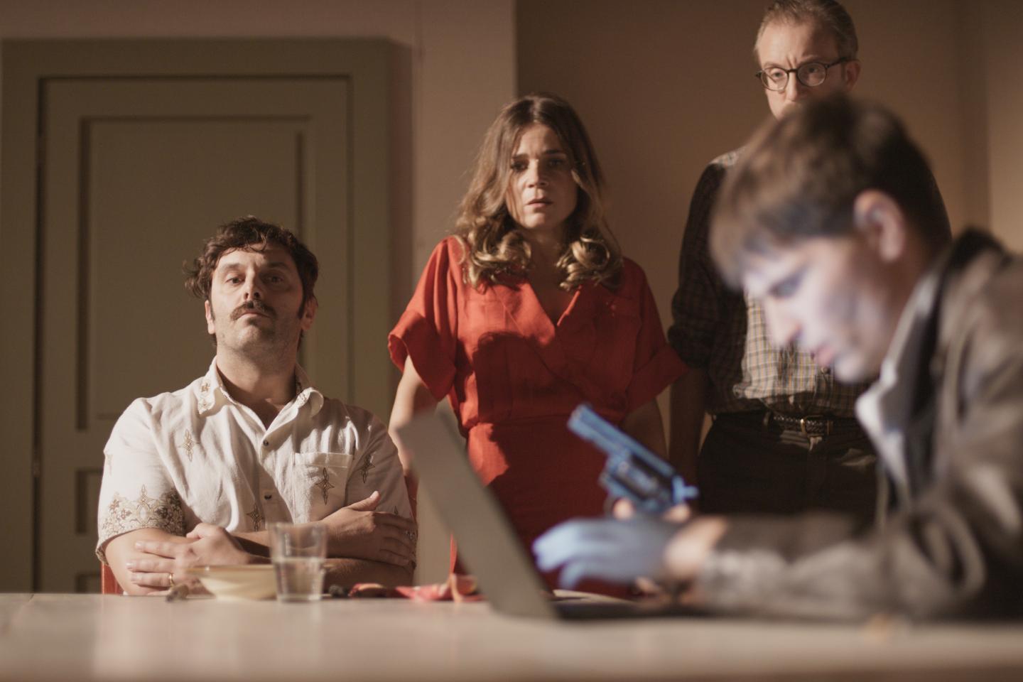 les 3 acteurs de théâtre stupéfiés devant le nouveau metteur en scène, armé, en plein exercice d'ecriture